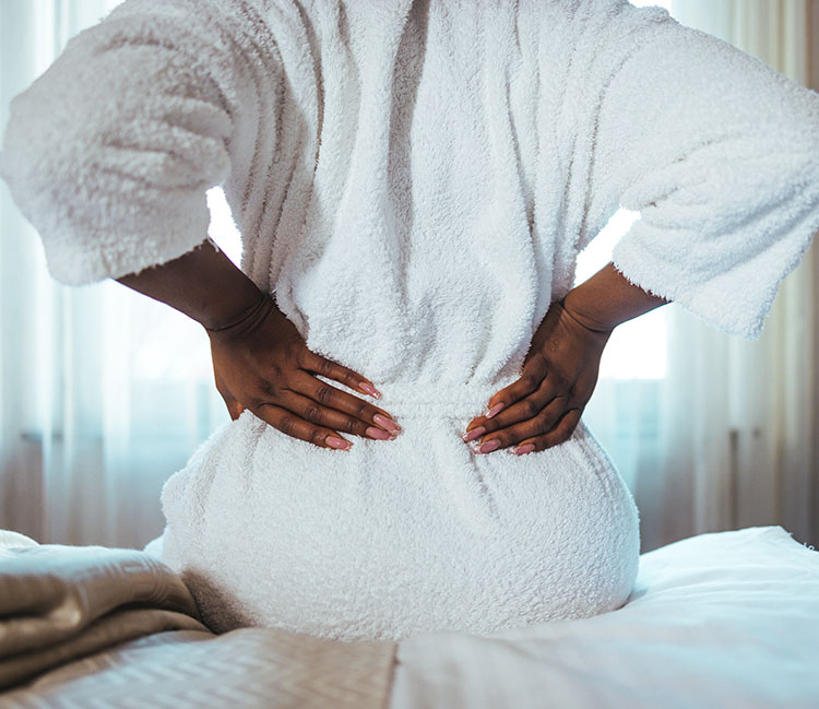 Woman suffering from back pain because of uncomfortable mattress