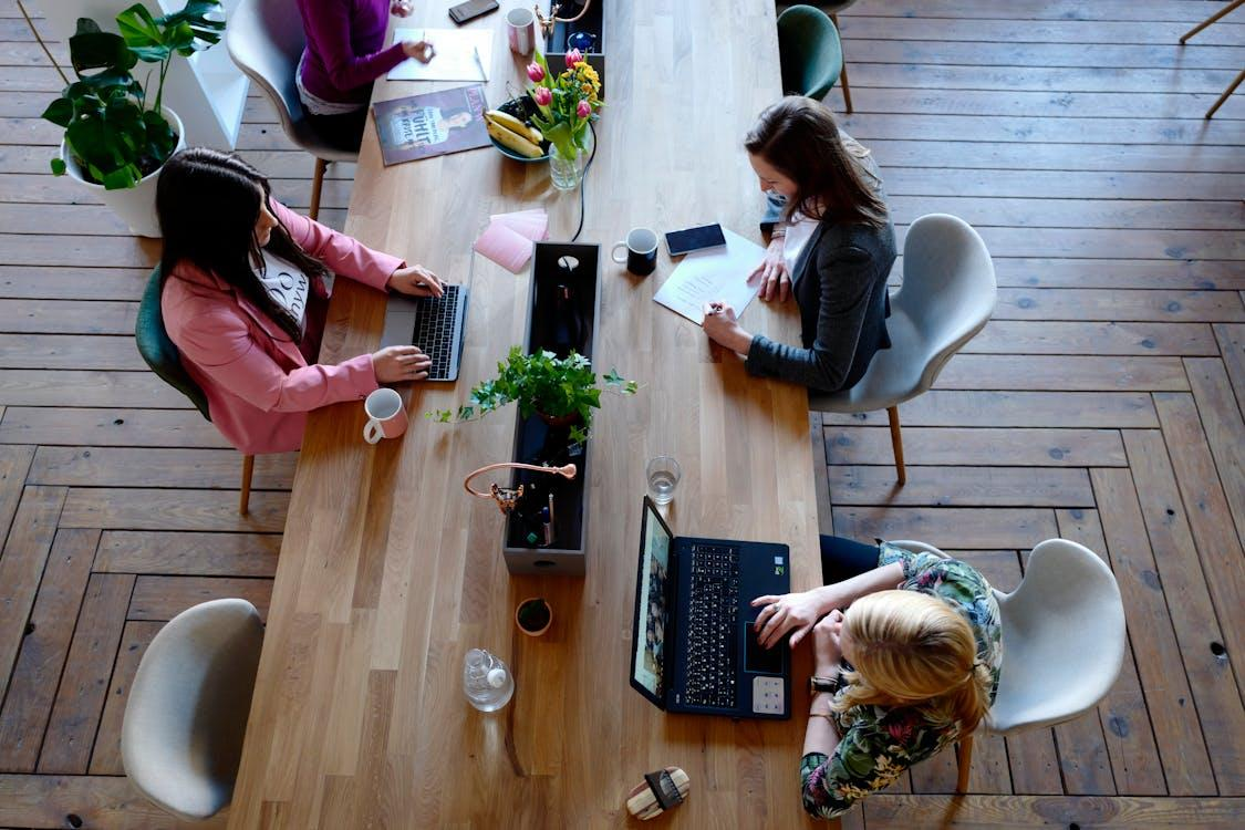 An aerial view of employees working on the same workstation