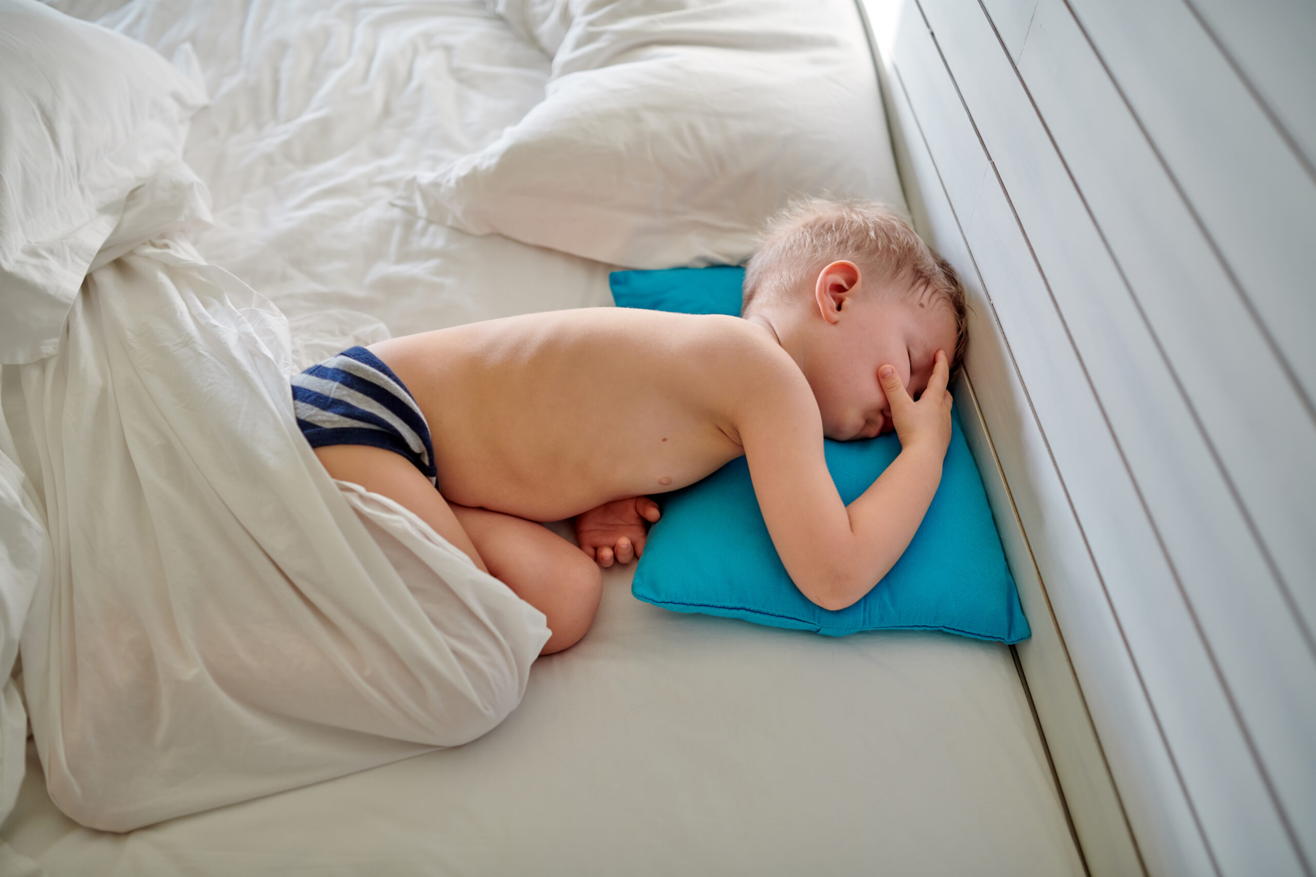 Toddler boy sleeping on blue pillow