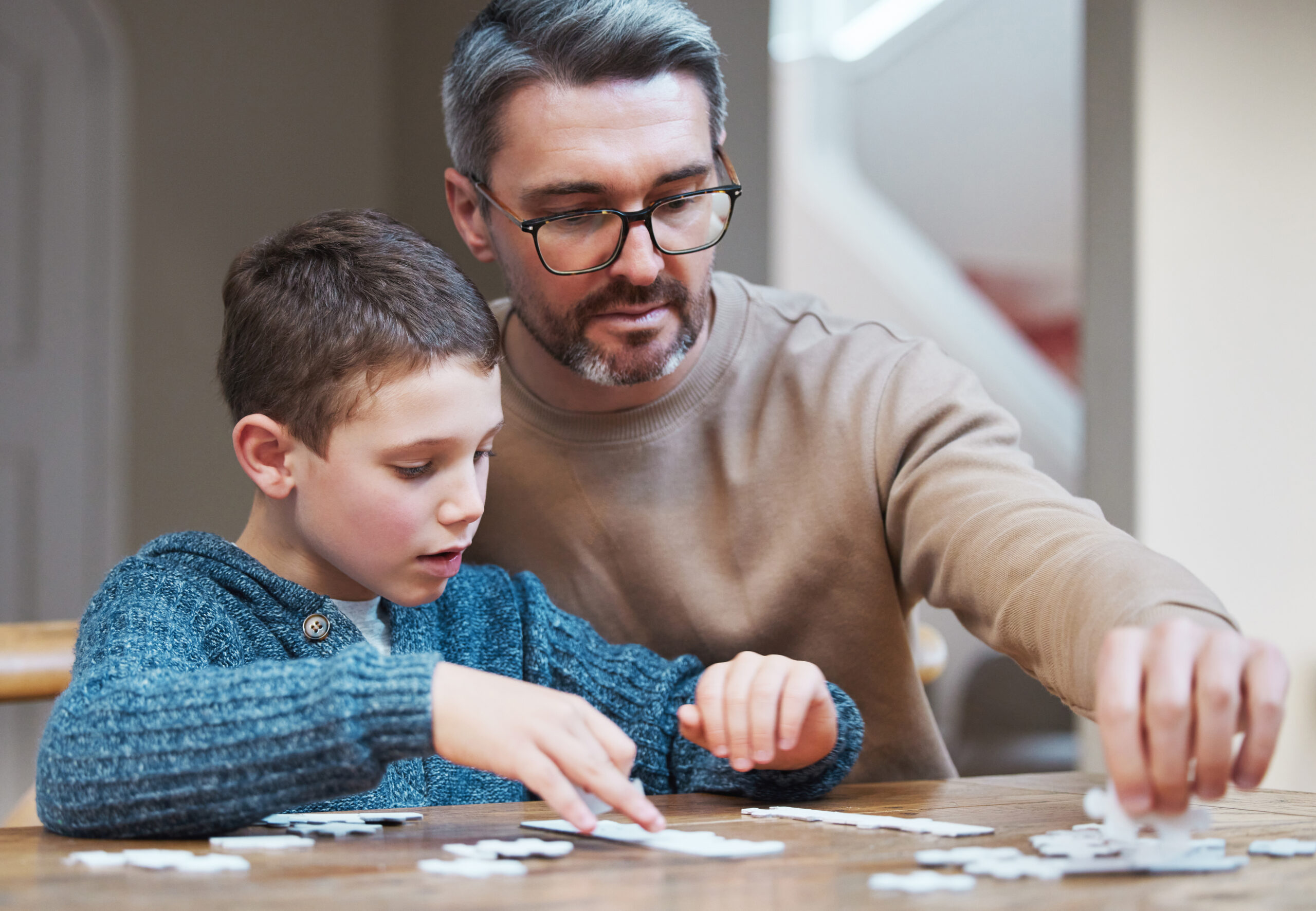 father and son playing a jigsaw puzzle together